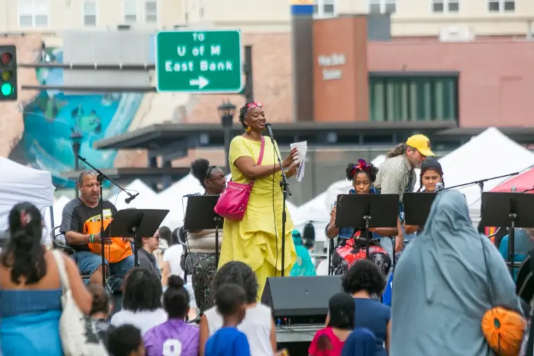 Person speaking on stage at Open Streets Cedar Riverside last year