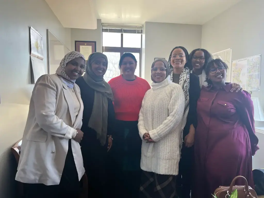 Group smiling with Rep. Sencer-Mura on Muslim Women's Day