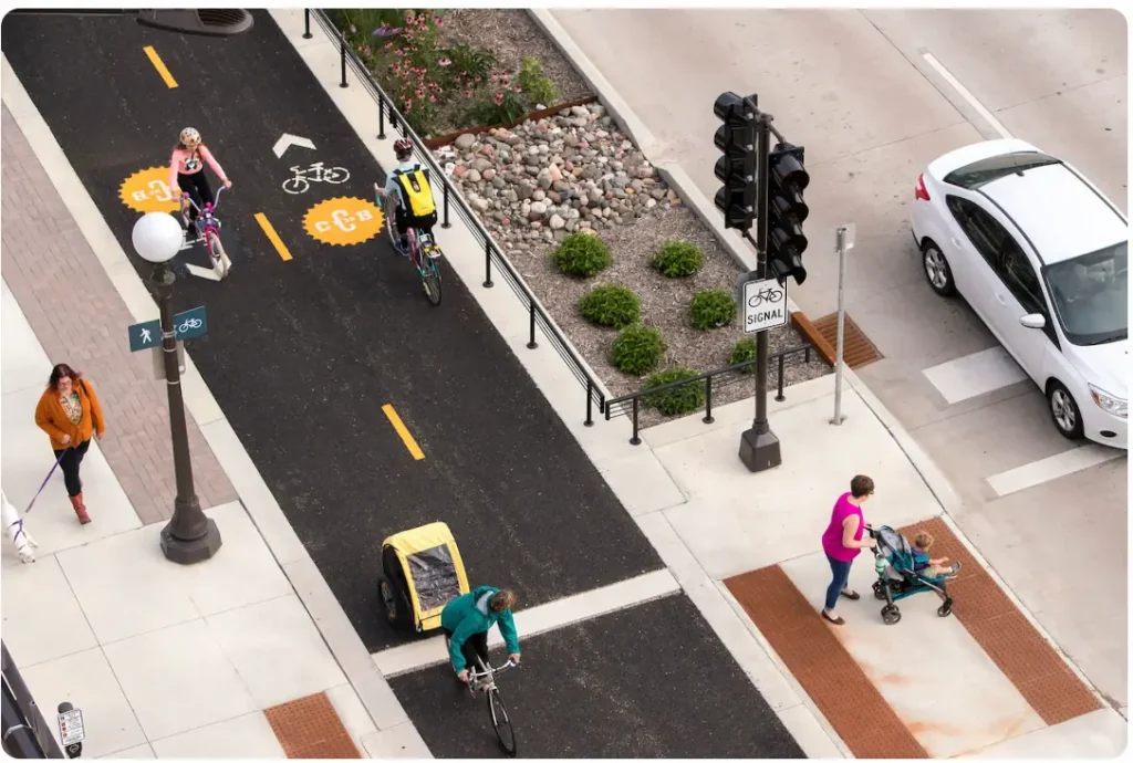 A realistic rendering of a street design that includes sidewalks, a two way bike lane, and clearly marked crossings.