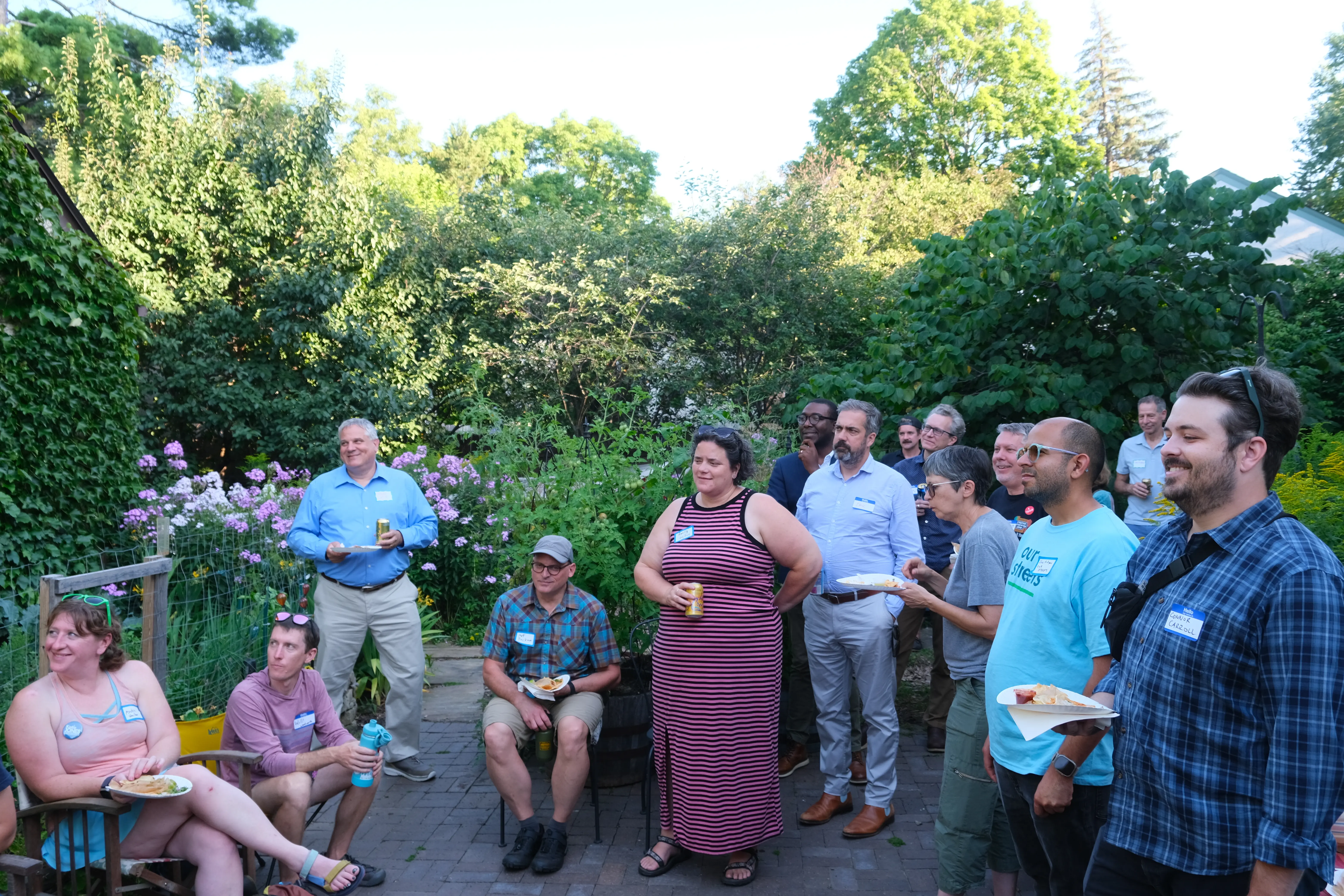 people with drinks and food gathered at a fundraiser in a backyard