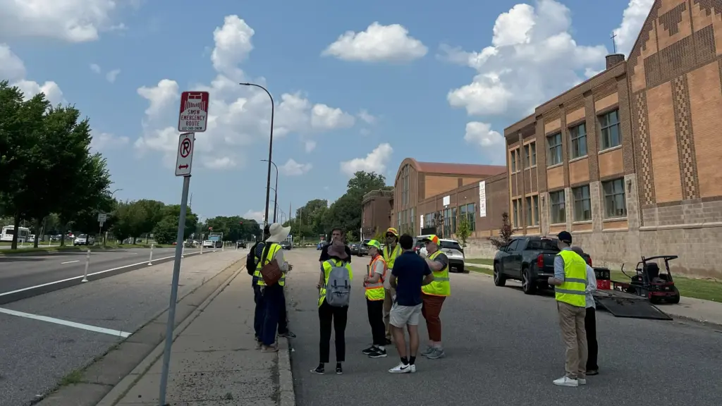 group of people in safety vests on service road next to Highway 55