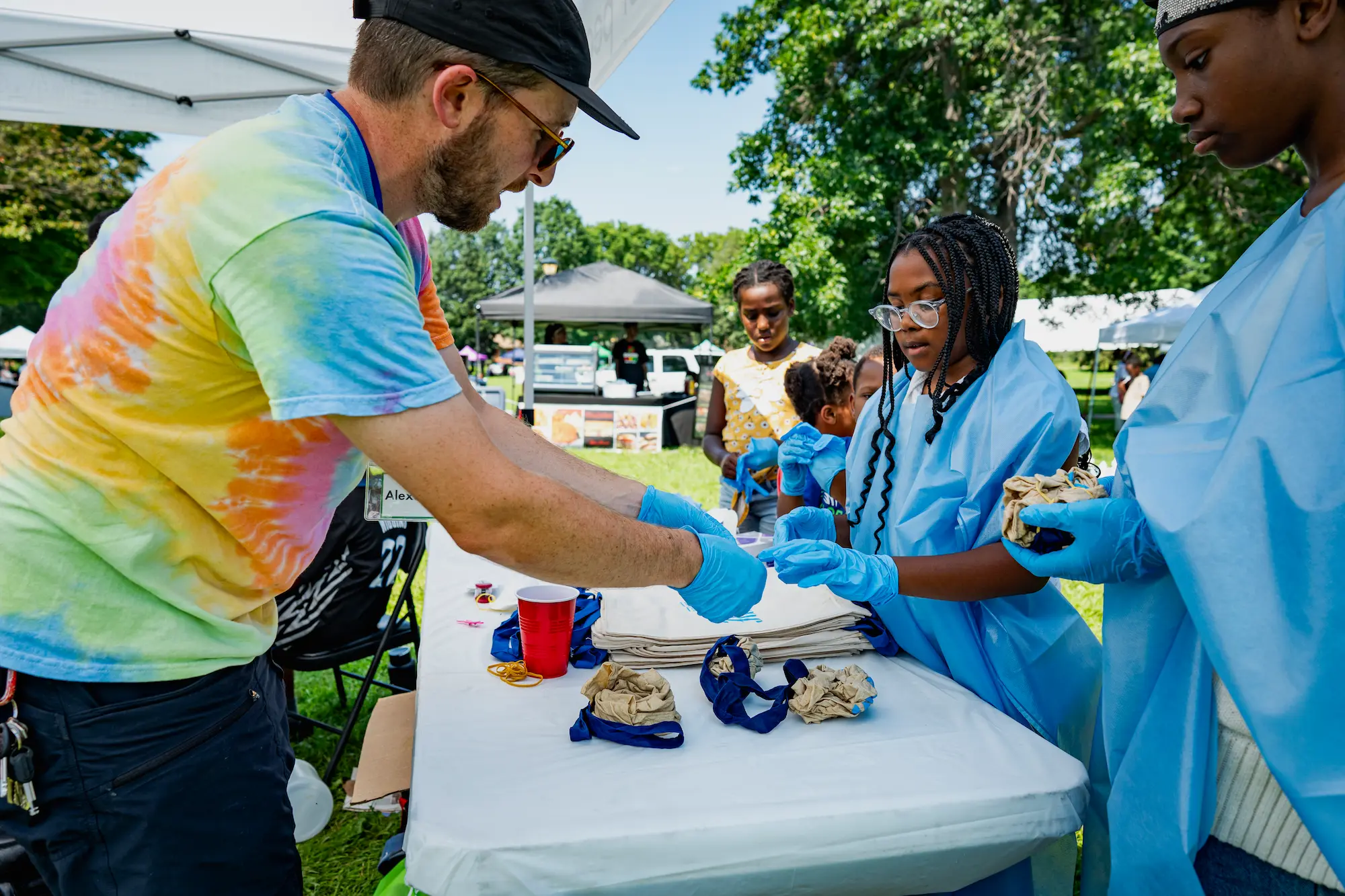 volunteer helping kids tie dye
