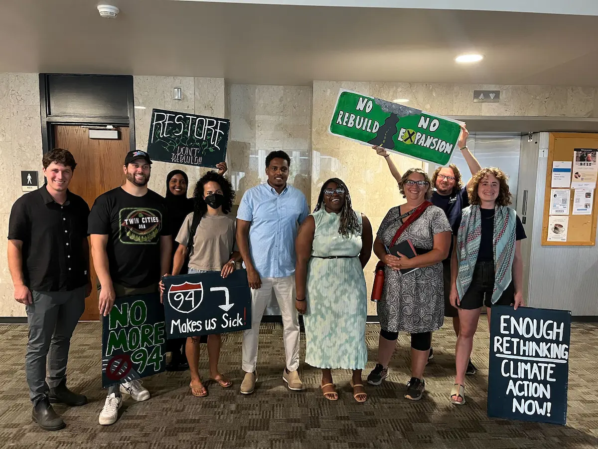 supporters standing with Councilmembers Jamal Osman and Robin Wonsley