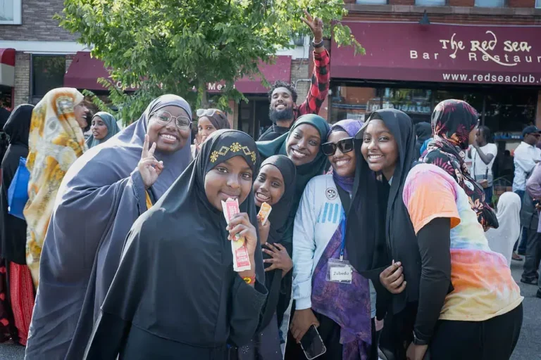 Group of young women and volunteers smiling for the camera at Cedarfest