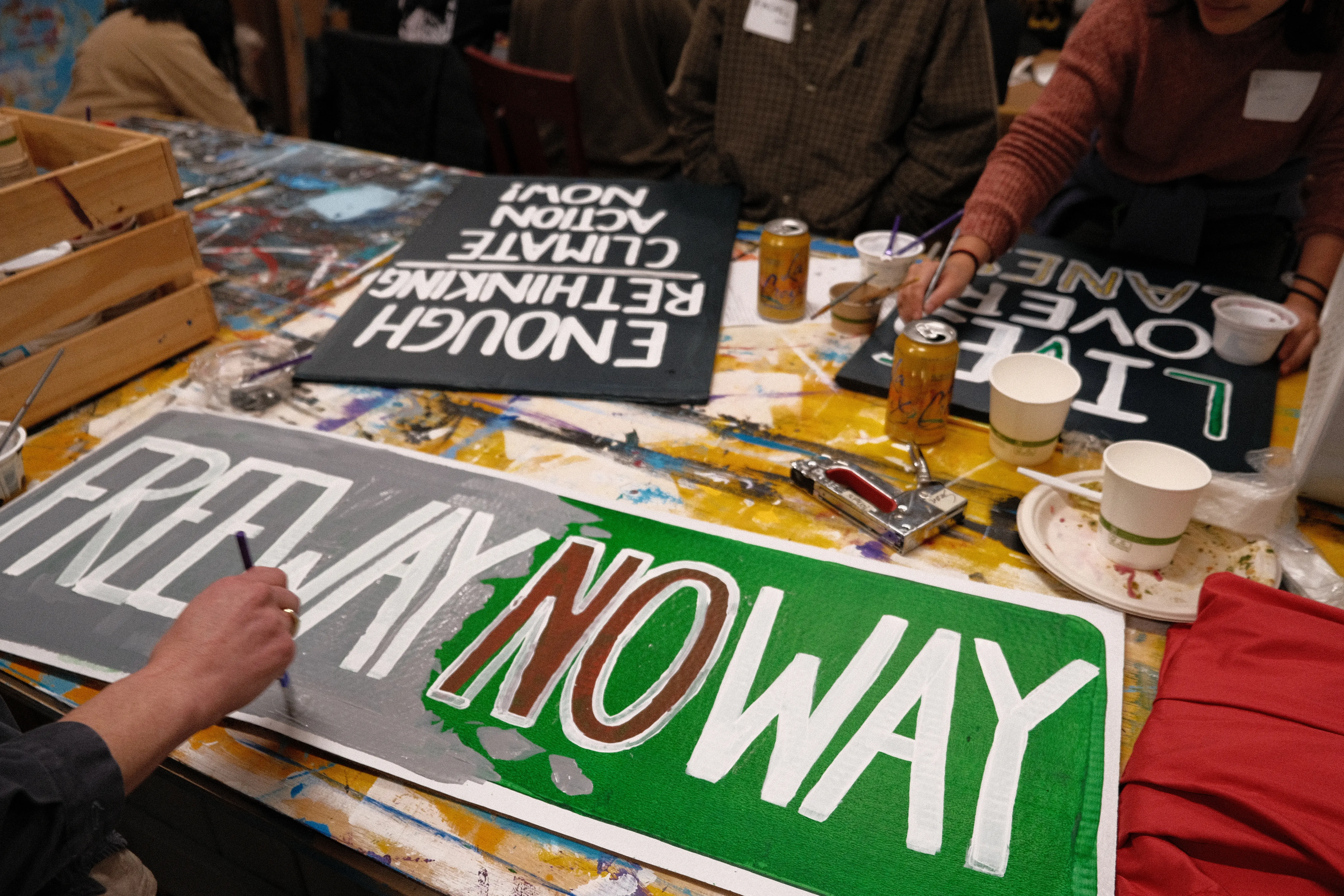 people painting freeway protest signs